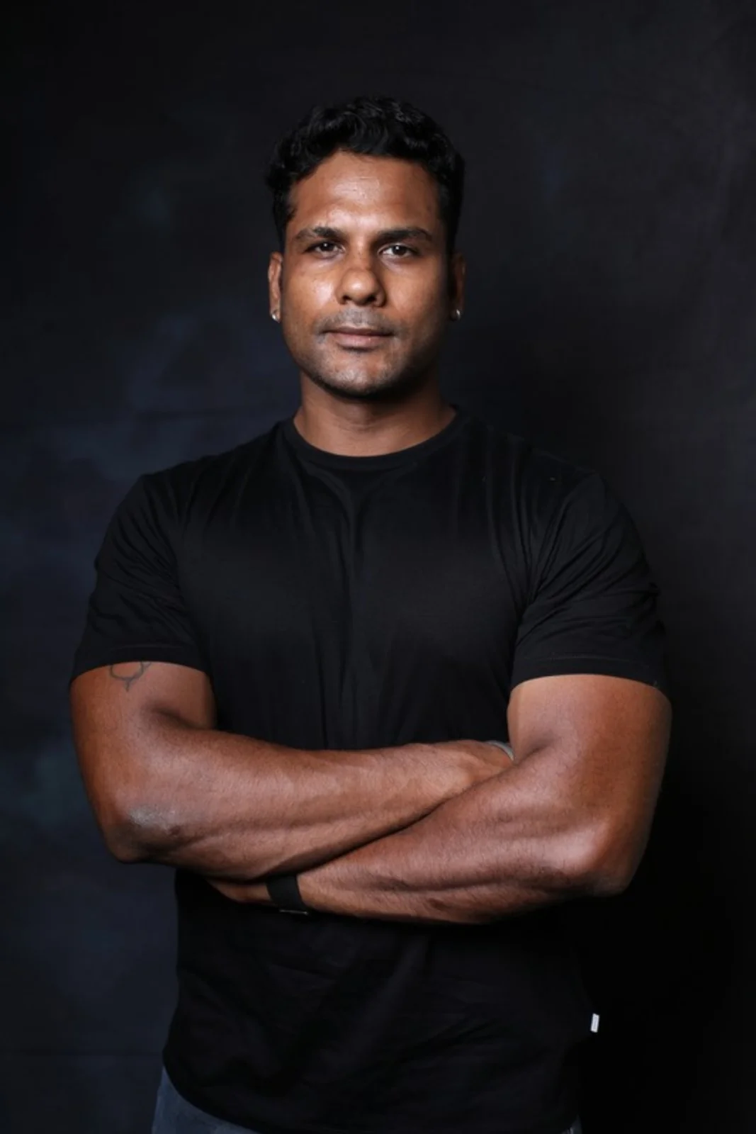 Guhayavarman, founder and head coach of CALIBRATE, in a black t-shirt with arms crossed